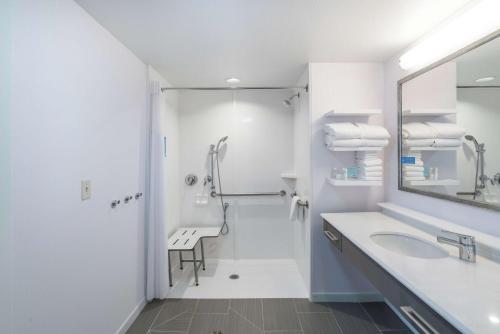 baño blanco con ducha y lavamanos en Hampton Inn & Suites Newburgh Stewart Airport, NY, en Newburgh
