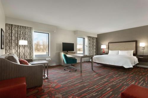 Habitación de hotel con cama, escritorio y TV. en Hampton Inn & Suites St. Louis/Alton, IL, en Alton