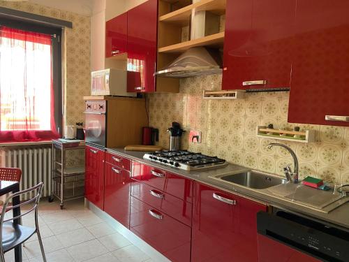 una cocina con armarios rojos y fregadero en Guest House MICINI en Druento