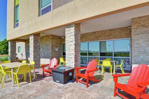 a patio with colorful chairs and tables and windows at Home2 Suites By Hilton Dayton Vandalia in Dayton