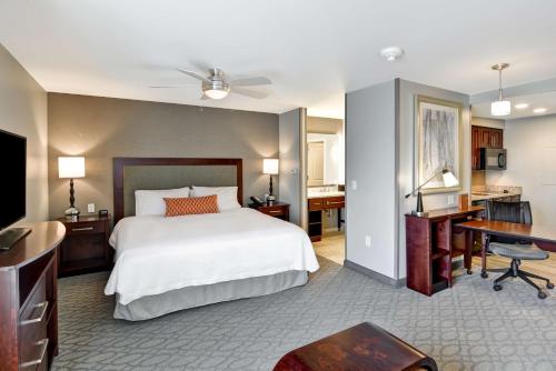 Habitación de hotel con cama, escritorio y escritorio. en Homewood Suites By Hilton New Hartford Utica en Clinton