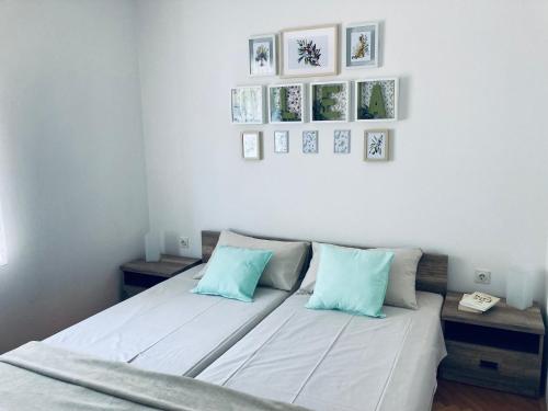 a bedroom with a bed with blue pillows and pictures on the wall at Apartment Olea in Izola