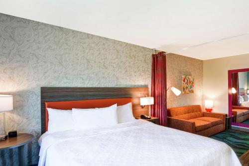 a hotel room with a large bed and a chair at Home2 Suites By Hilton Dayton Vandalia in Dayton