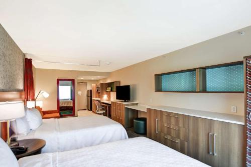 a hotel room with two beds and a television at Home2 Suites By Hilton Dayton Vandalia in Dayton
