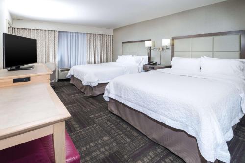a hotel room with two beds and a flat screen tv at Hampton Inn & Suites Wilson I-95 in Wilson