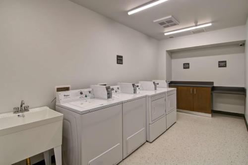 a laundry room with white washers and a sink at Hampton Inn & Suites by Hilton Grande Prairie in Grande Prairie