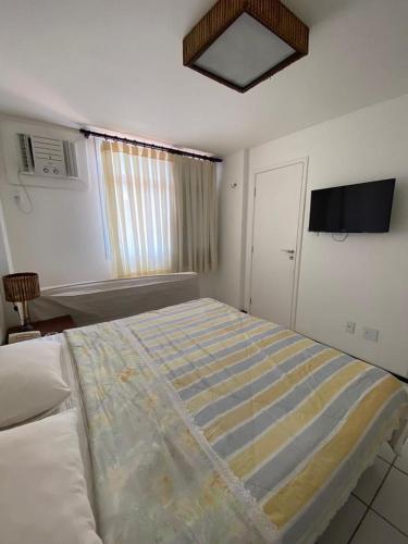 a bedroom with a bed and a tv on the wall at GRAN FLAT LENCOIS/ BARREIRINHAS - 201C in Barreirinhas