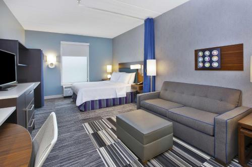 a hotel room with a bed and a couch at Home2 Suites By Hilton Pittsburgh Area Beaver Valley in Monaca