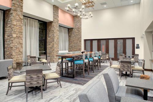 a restaurant with tables and chairs in a room at Hampton Inn Suites Flagstaff East in Flagstaff