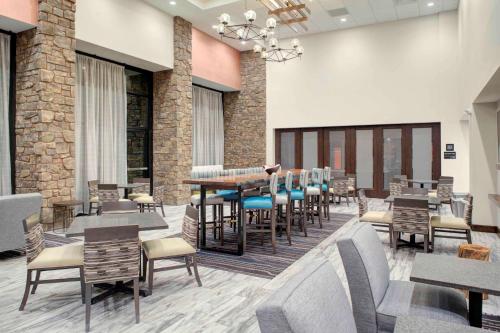 a restaurant with tables and chairs in a room at Hampton Inn Suites Flagstaff East in Flagstaff