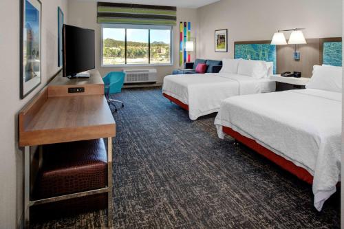 Hampton Inn Suites Flagstaff East في فلاغستاف: غرفة فندقية بسريرين وتلفزيون بشاشة مسطحة