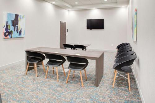 a conference room with a wooden table and black chairs at Hampton Inn Suites Flagstaff East in Flagstaff