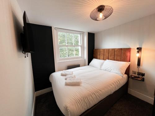 een kleine slaapkamer met een bed en een raam bij Argo Hotel - Kings Cross in Londen