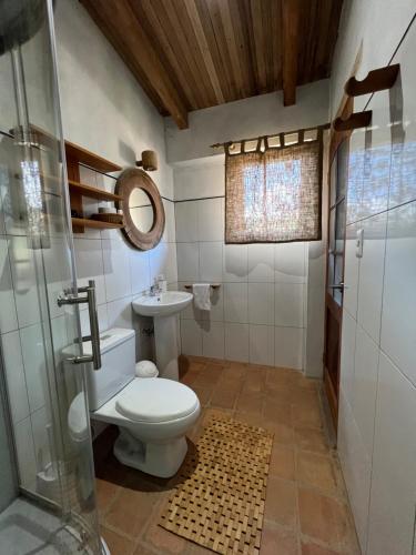 La salle de bains est pourvue de toilettes et d'une douche en verre. dans l'établissement Los Viajeros B&B, à Leimebamba