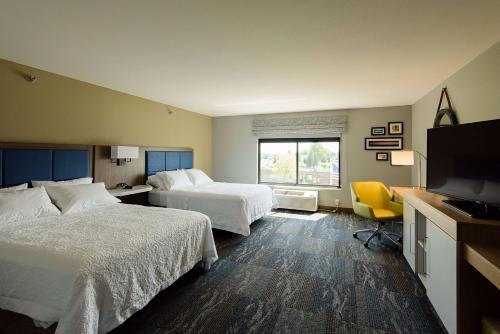 a hotel room with two beds and a flat screen tv at Hampton Inn Superior Duluth, Wi in Superior