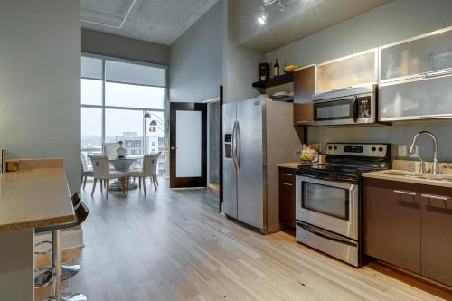 a kitchen with stainless steel appliances and a dining room at Lux living in this 6th floor condo located in East Nashville minutes to downtown in Nashville