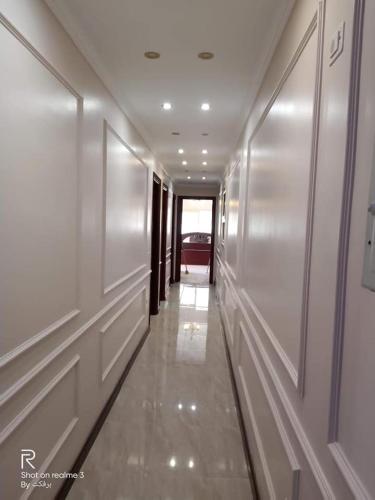 um corredor num edifício com paredes e tectos brancos em elite department em Kafr al Muşayliḩah
