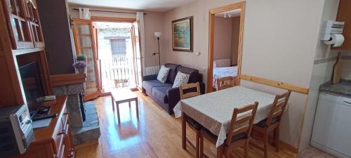 a living room with a table and a couch at Apartamento El Refugio de Sara in Benasque
