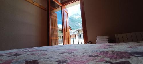 a bedroom with a bed with a large window at Apartamento El Refugio de Sara in Benasque