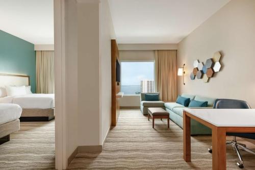 um quarto de hotel com uma cama e um sofá em Embassy Suites By Hilton Sarasota em Sarasota
