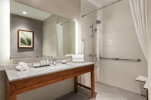 a bathroom with a sink and a shower at Embassy Suites By Hilton Sarasota in Sarasota