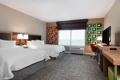 メルボルンにあるHampton Inn & Suites West Melbourne-Palm Bay Roadのベッド2台と薄型テレビ付きのホテルの部屋