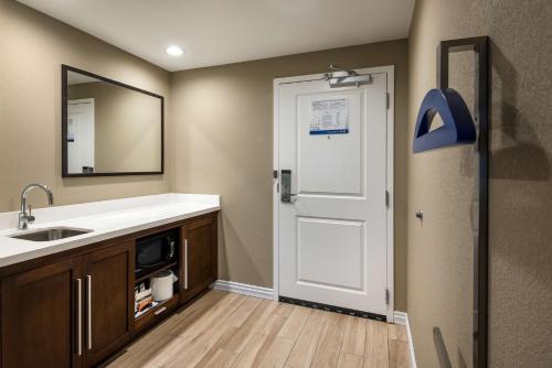 a bathroom with a sink and a mirror and a door at Hampton Inn & Suites West Melbourne-Palm Bay Road in Melbourne