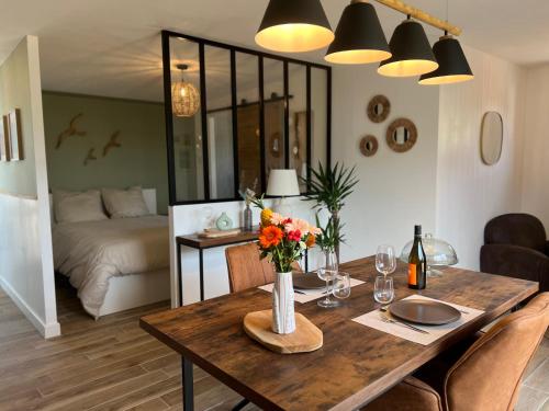 une salle à manger avec une table avec des fleurs et un lit dans l'établissement Cottage à la campagne, à Quimerch