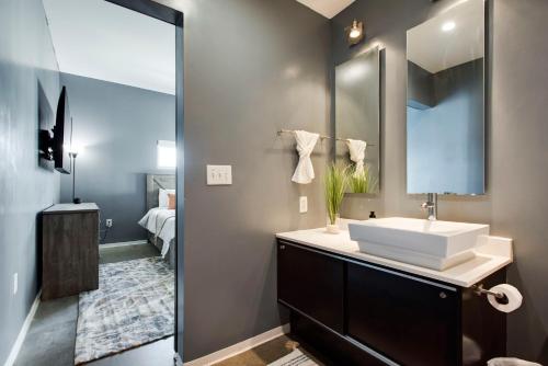 a bathroom with a sink and a mirror at Sleek and Spacious Condo In East! in Nashville