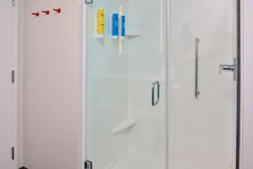een douche met een glazen deur met boeken erop bij Tru By Hilton Stuttgart in Stuttgart