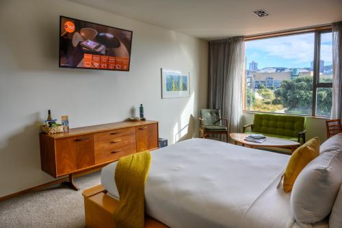 um quarto de hotel com uma cama grande e uma janela em Ohtel Wellington em Wellington