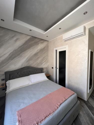 a bedroom with a bed with a pink blanket on it at Suites Matteotti 57 in Civitavecchia