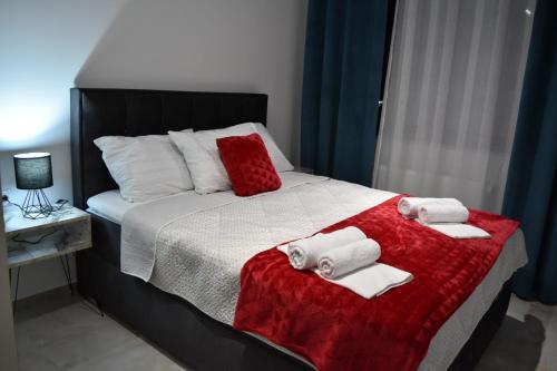 a bedroom with a bed with towels on it at Lux Apartman Crnjanski II, Jagodina in Jagodina