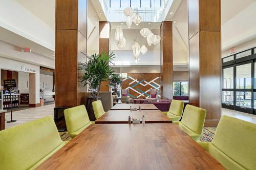 a large dining room with a long table and yellow chairs at Hilton Garden Inn Edmond/Oklahoma City North in Edmond