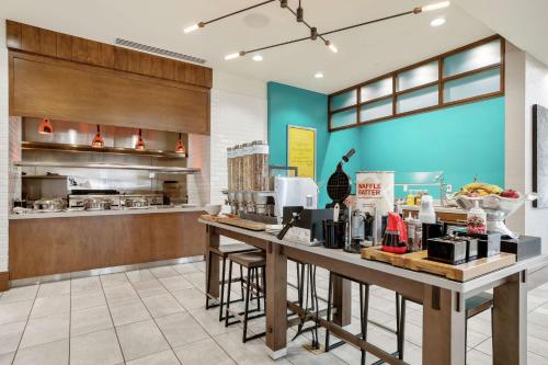 a kitchen with a counter in a restaurant at Hilton Garden Inn Edmond/Oklahoma City North in Edmond
