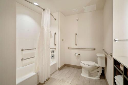 a white bathroom with a toilet and a shower at Hilton Garden Inn Edmond/Oklahoma City North in Edmond