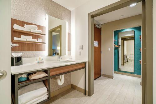 een badkamer met een wastafel en een grote spiegel bij Hilton Garden Inn Edmond/Oklahoma City North in Edmond