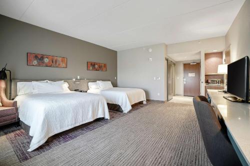 a hotel room with two beds and a flat screen tv at Hilton Garden Inn Edmond/Oklahoma City North in Edmond