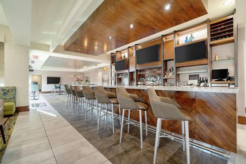 a bar with a row of stools in a room at Hilton Garden Inn Edmond/Oklahoma City North in Edmond