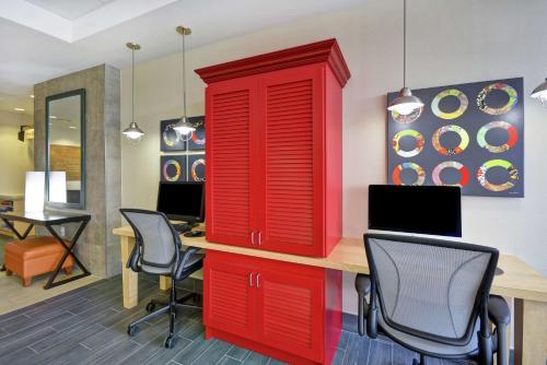a red cabinet in a room with a desk and chairs at Home2 Suites by Hilton Brownsville in Brownsville