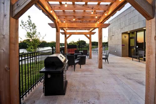 a pergola with chairs and tables on a patio at Home2 Suites By Hilton Oklahoma City Airport in Oklahoma City