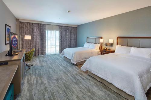 a hotel room with two beds and a television at Hampton Inn & Suites Sacramento at CSUS in Sacramento