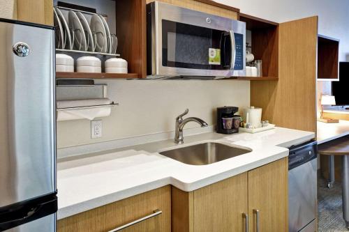 a kitchen with a sink and a microwave at Home2 Suites By Hilton Oklahoma City Airport in Oklahoma City