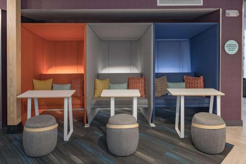 a room with two tables and two stools at Tru by Hilton Garland Richardson in Garland