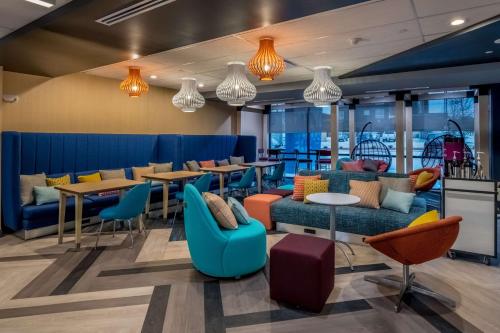 a restaurant with blue and orange chairs and tables at Tru by Hilton Garland Richardson in Garland