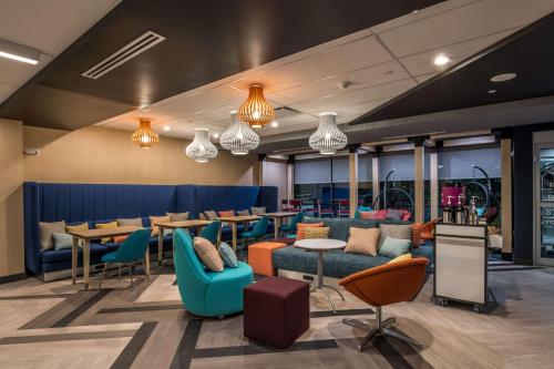 a restaurant with blue chairs and tables and windows at Tru by Hilton Garland Richardson in Garland