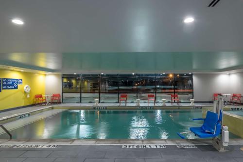 a swimming pool with a blue chair in a building at Tru by Hilton Garland Richardson in Garland