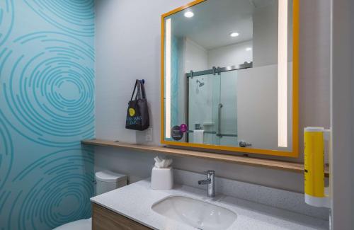 a bathroom with a sink and a mirror at Tru by Hilton Garland Richardson in Garland