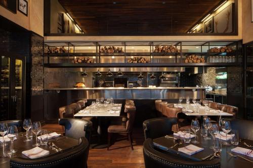 a restaurant with tables and chairs and a bar at The Porter Portland, Curio Collection By Hilton in Portland