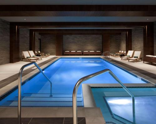 a pool in a hotel with chairs and tables at The Porter Portland, Curio Collection By Hilton in Portland